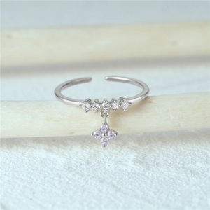 Detail of S925 silver open ring with micro-set zircons and pink clover pendant