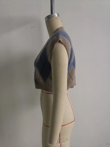 Detailed side view of a cropped argyle knit vest with V-neck on a professional mannequin