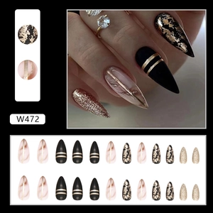 Black almond press-on nails with amber gold foil accents and glitter stiletto finish