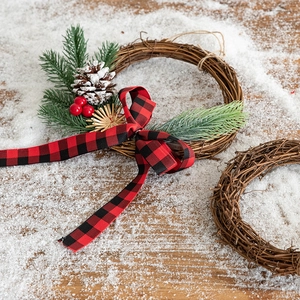 Natural vine Christmas wreath with buffalo plaid bow, pine needles, and red berries decor