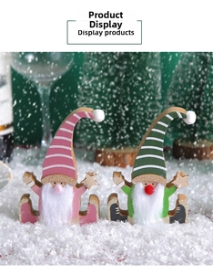 Detail of two festive wooden Christmas gnomes with striped hats and plush white beards
