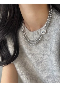 Macro detail of double-layer grey glass pearl necklace with square zircon clasp on model