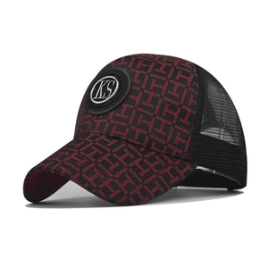 Detailed close-up of KS logo on red plaid baseball cap with black mesh back