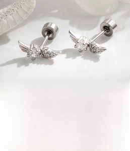 Macro detail of silver angel wing stud earrings with micro-set zircons and screw backs