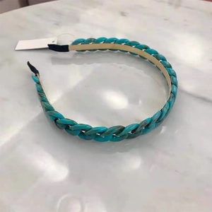 Candy colored green chain headband with resin links and metal frame on marble background