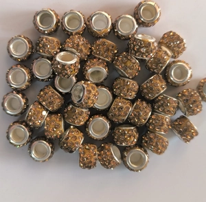 Macro view of 7x12mm cylindrical champagne rhinestone beads with silver metal core