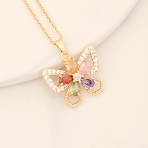 Close-up of a butterfly pendant with colorful zircons on a delicate gold-plated chain