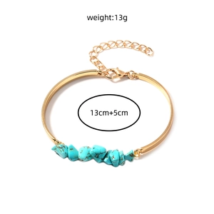 Detailed view of a gold chain bracelet with turquoise stones and size markings