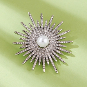 Detailed view of silver sunflower brooch with shimmering crystals and a center white pearl
