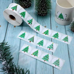 500 Christmas tree roll stickers for holiday gift decoration on light blue wood background