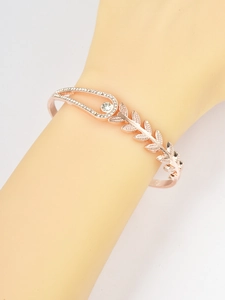 Macro detail of rose gold wheat leaf bracelet with sparkling crystals on model