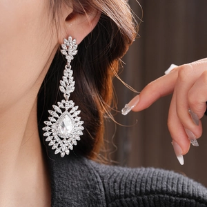 Close-up of elegant silver tassel earrings with crystals on model for a luxury look