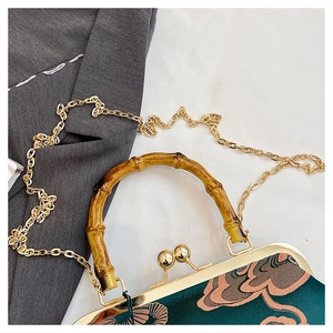 Detail aus grünem Blumensatin mit Bambusgriff und goldenem Metallverschluss