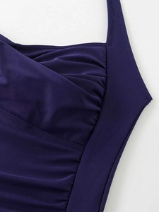 Detail of the deep purple wrap design and stitching on the chest of this swimsuit