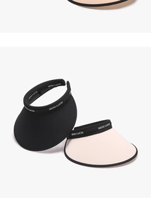 Detail of wide-brim sun visor hats in black and beige with elegant textile texture