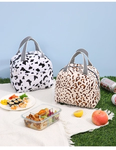 Détail de sacs à lunch isothermes aux motifs léopard et vache sur nappe de pique-nique