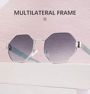 Detailed view of silver multilateral sunglasses with purple gradient lenses on a white pedestal
