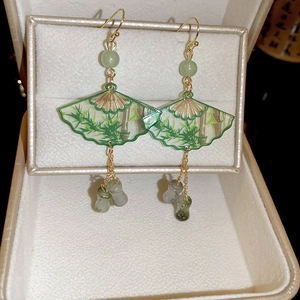 Detailed close-up of Chinese fan earrings with bamboo pattern and green beads