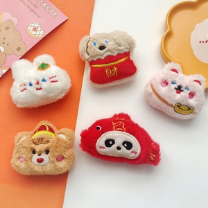 Detailed view of five plush animal brooches with festive embroidery and soft texture