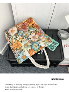 Detail of colorful floral embroidery patterns and thick white cotton rope handles on a tote bag