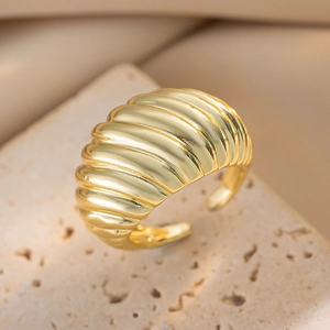 Elegant gold plated geometric textured open ring on a natural stone display stand