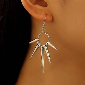Close-up of silver punk spiked earrings with five conical charms on model's ear