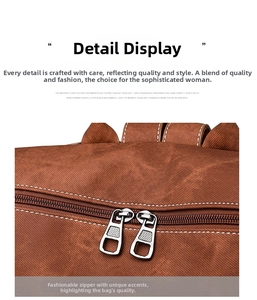 Close-up of brown vintage backpack featuring durable dual metal zippers and white stitching