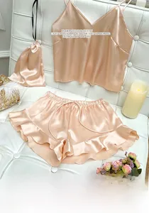 Champagne silk satin pajama set with V-neck camisole, ruffled shorts, and a matching bag