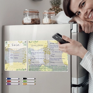 Close-up of magnetic acrylic weekly planner and to-do list boards on stainless steel fridge