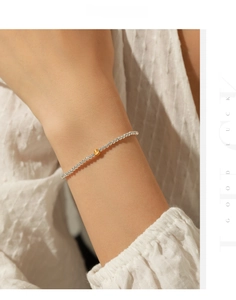 Macro shot of s925 silver beaded bracelet with a single gold bead accent on wrist
