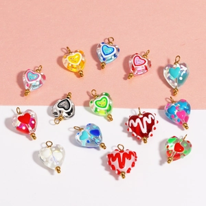Macro shot of colorful heart-shaped lampwork glass beads with detailed metal charms