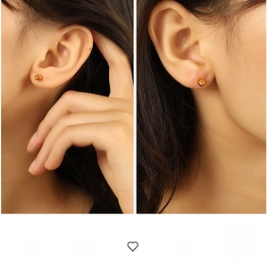 Close-up of stylish polished gold ball stud earrings showing elegant spherical design