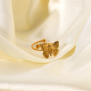 Détail macro d'une bague papillon plaquée or 18 carats avec anneau torsadé sur soie