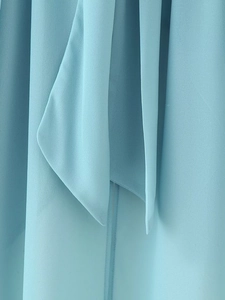 Detailed macro view of light blue chiffon fabric showing soft drapes and neckline textures