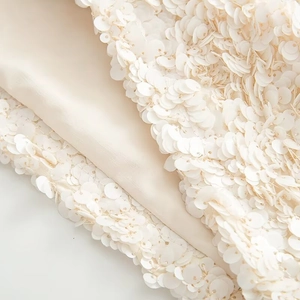 Detail of shimmering cream-white sequins sewn on soft premium textile fabric