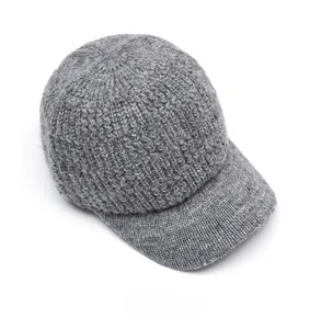 Detailed close-up of grey knitted baseball cap showing thick wool texture and brim