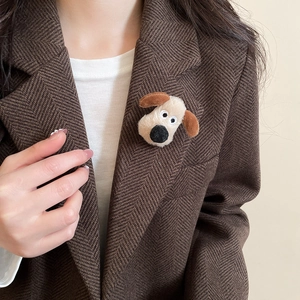 Close-up of cute flocked puppy brooch on a brown herringbone blazer lapel for style