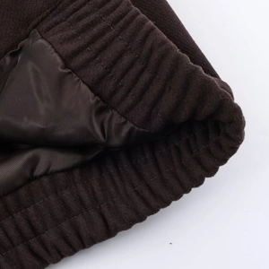 Détail de la veste en fausse fourrure marron foncé avec doublure satin et ourlet élastique