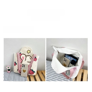 Detail view showing large capacity and internal storage of the cute cartoon canvas tote