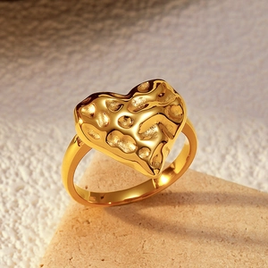Macro detail of heart-shaped gold ring featuring a unique hammered meteorite texture