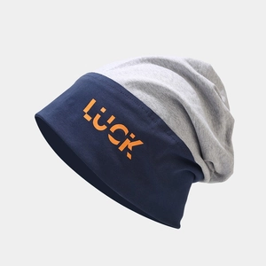 Navy and grey slouchy beanie with orange LUCK pixel lettering shown at a 45-degree angle