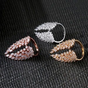 Detailed view of wing-shaped rings with sparkling cubic zirconia in three metal colors