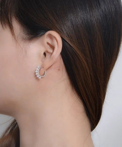Detail shot of a model wearing minimalist silver sterling earrings with white pearls
