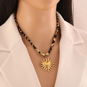 Close-up of leopard print rope necklace with golden sun-heart pendant on model
