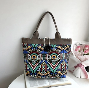 Detailed close-up of a large ethnic tote bag with colorful geometric patterns on a desk