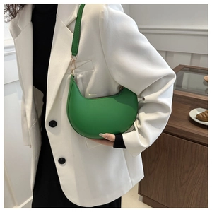 Detail of green crescent underarm bag with gold hardware and stylish stitching