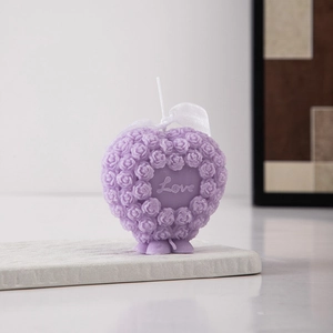 Detailed view of a purple heart-shaped candle with rose textures and Love engraving