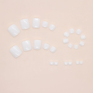 Vue à plat de 24 faux ongles d'orteils blancs brillants de différentes tailles