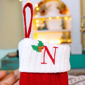 Red knit Christmas stocking ornament with white cuff and red embroidered letter N