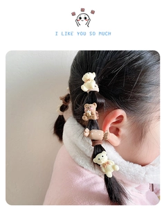 Detailed view of cute bear and candy hair ties on braided hair for little girls